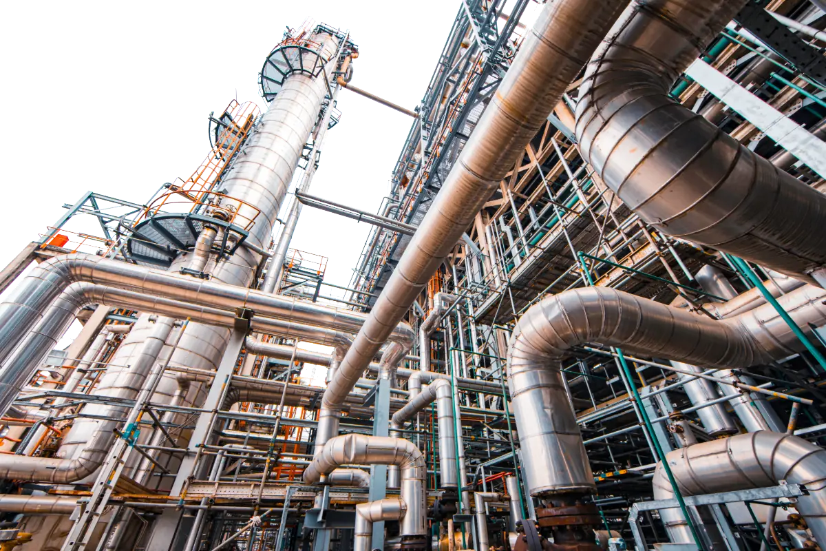 Stainless columns, pipework and gantries of an oil refinery seen from below, the operational technology that carries long-lived certificates and keys.