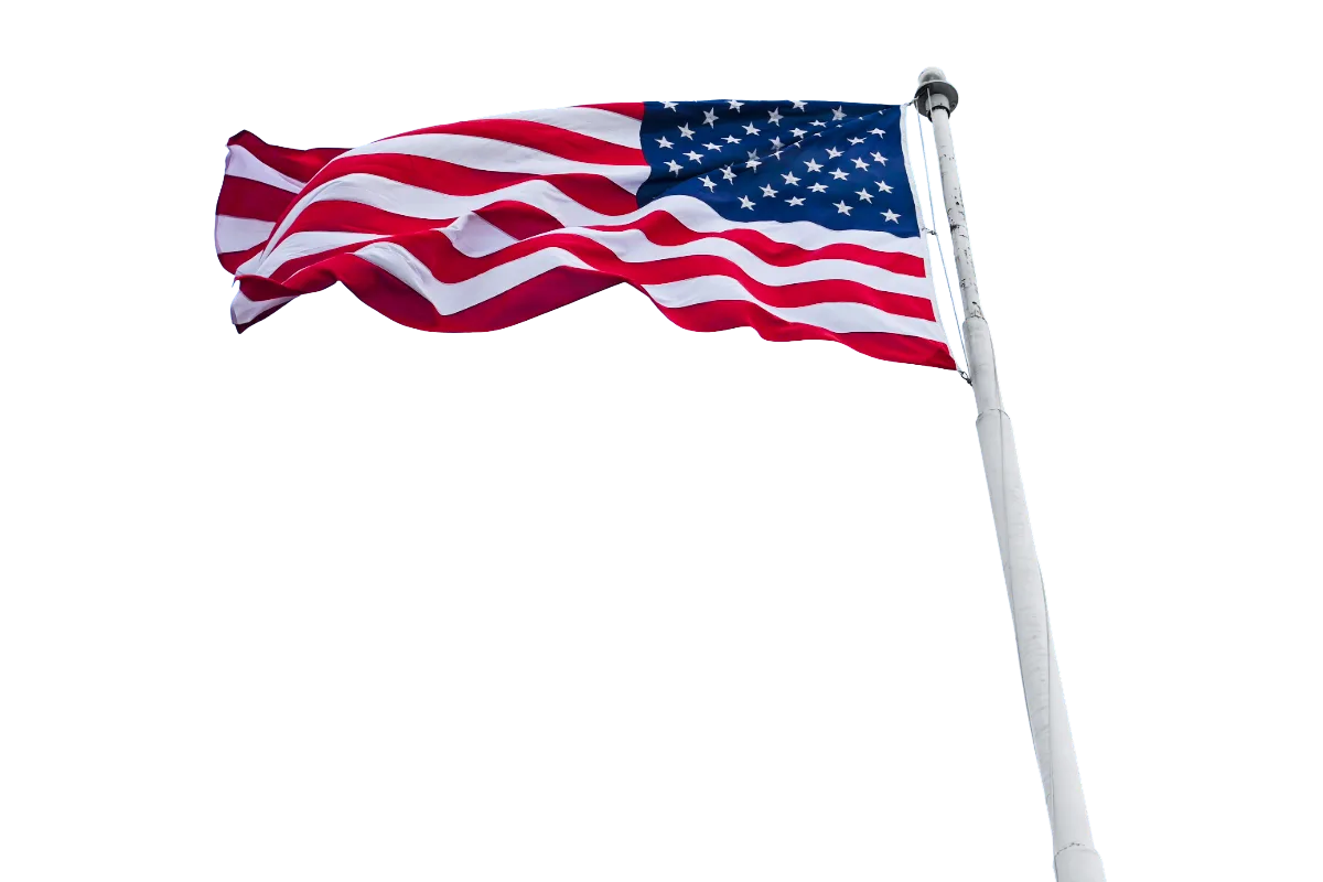 A United States flag flying from a tall flagpole.
